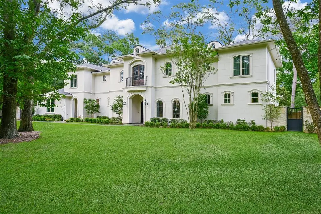 White stucco estate home on a wide lawn at 12 Valley Forge Drive